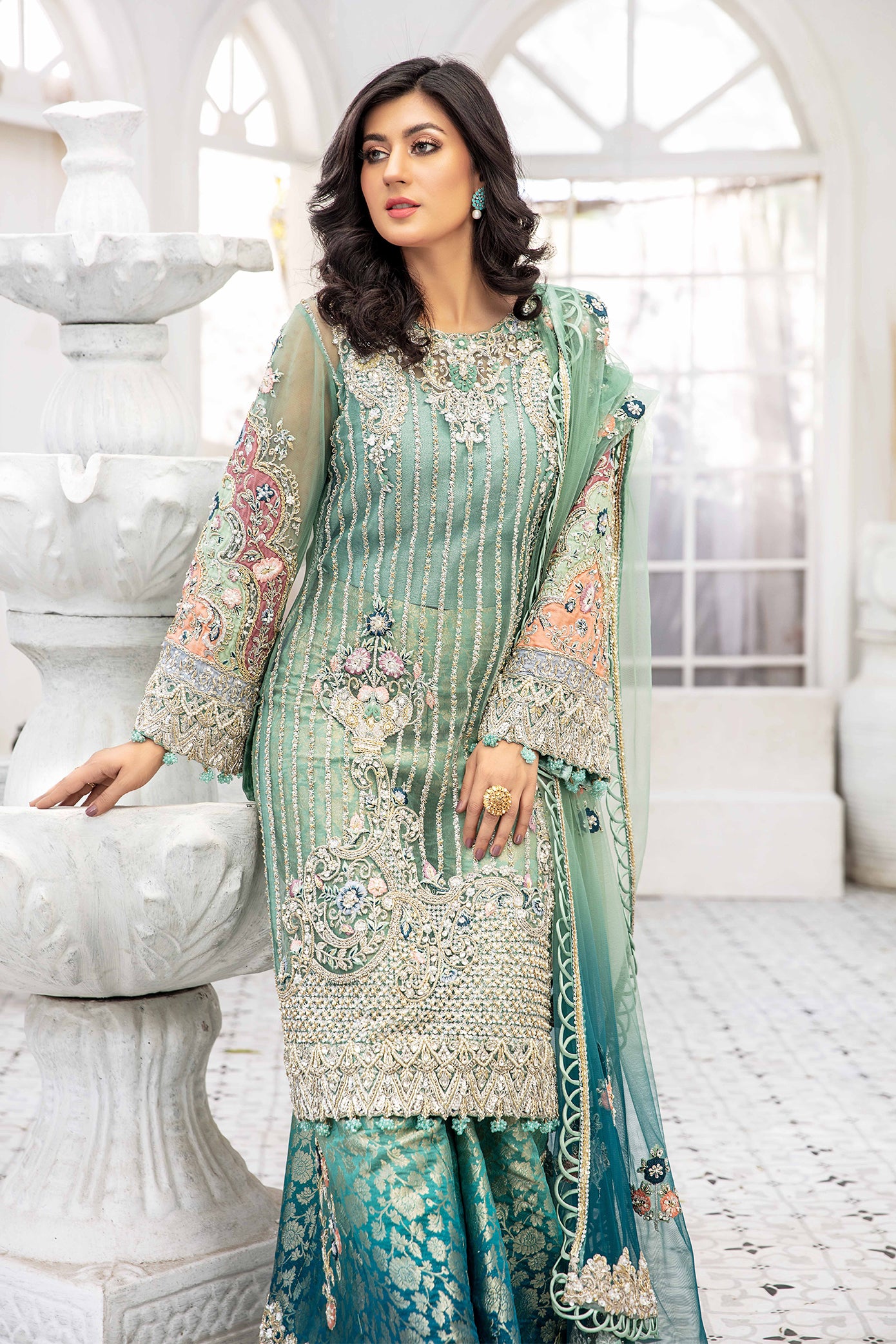A beautiful turquoise blue double shaded Pakistani formal dress with intricate silver work on the bodice and sleeves. The dress features a lovely dupatta that complements the elegant design. Perfect for formal events and special occasions, this dress showcases traditional Pakistani style with its mesmerizing beauty and charm.