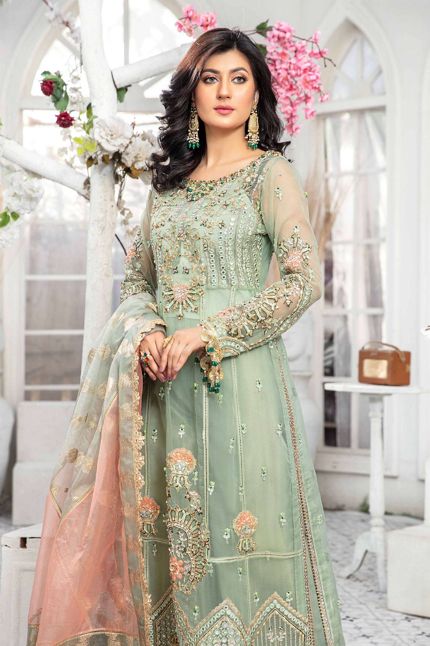 A mint green and peach Pakistani formal dress with intricate embroidery work in peach and green, paired with a peach-colored dupatta adorned with green embroidery. The dress is perfect for weddings and formal events, and the lightweight dupatta makes it comfortable to wear for extended periods.