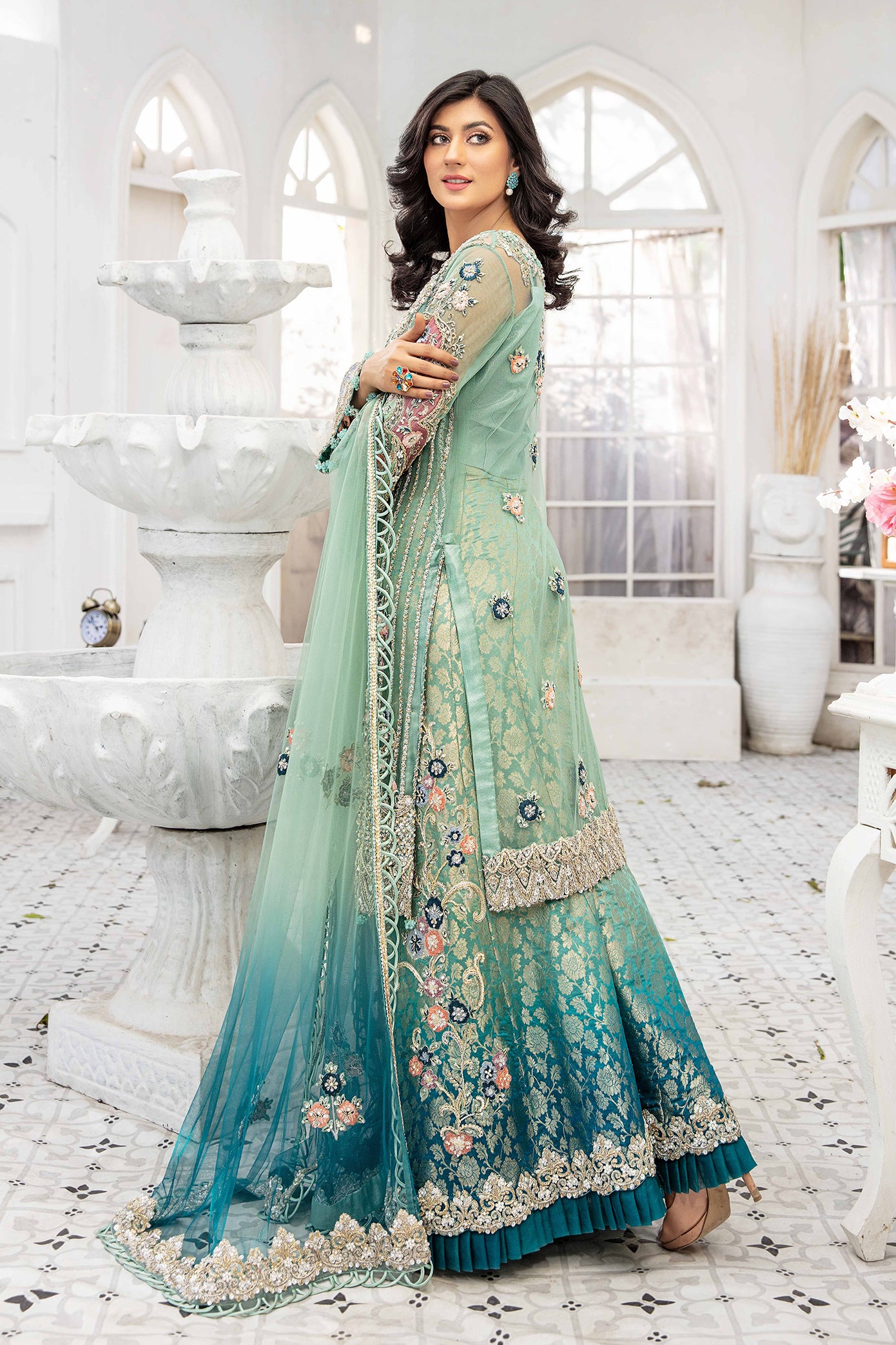 A beautiful turquoise blue double shaded Pakistani formal dress with intricate silver work on the bodice and sleeves. The dress features a lovely dupatta that complements the elegant design. Perfect for formal events and special occasions, this dress showcases traditional Pakistani style with its mesmerizing beauty and charm.