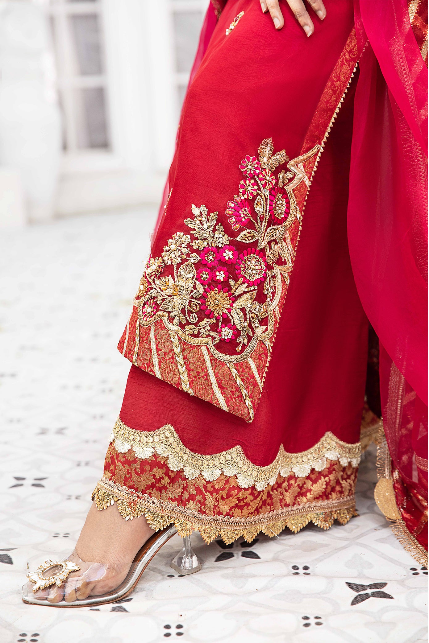 A beautiful Pakistani formal dress in shades of maroon and pink, with intricate gold work adorning the bodice, sleeves, and hemline. The dress features a flattering silhouette and is perfect for formal occasions.
