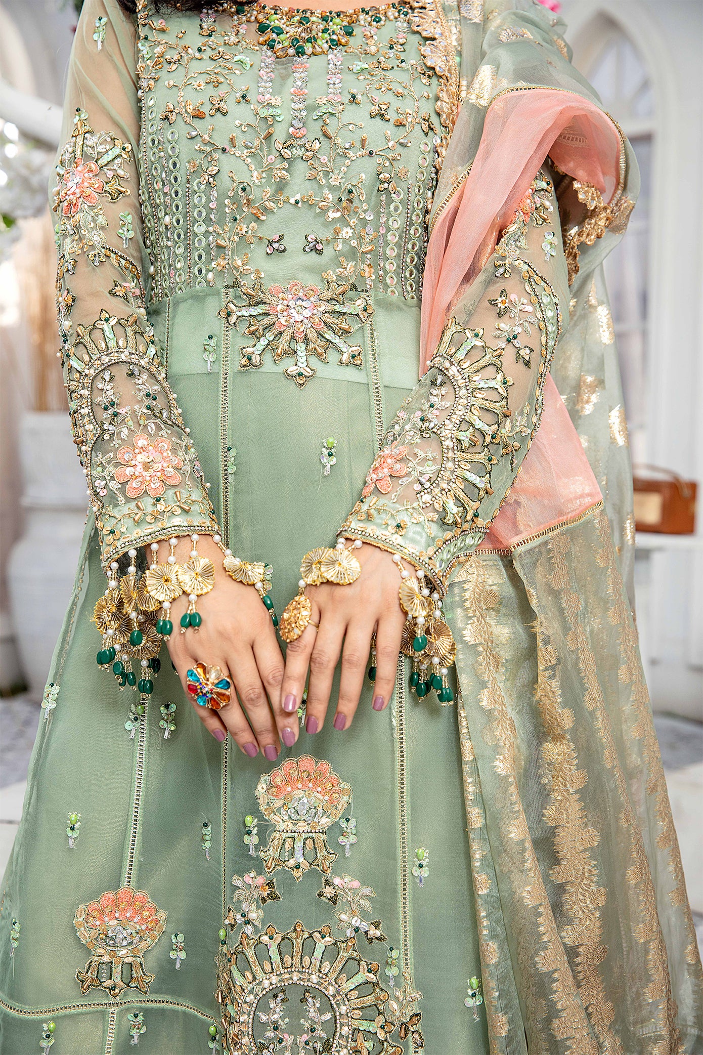 A mint green and peach Pakistani formal dress with intricate embroidery work in peach and green, paired with a peach-colored dupatta adorned with green embroidery. The dress is perfect for weddings and formal events, and the lightweight dupatta makes it comfortable to wear for extended periods.