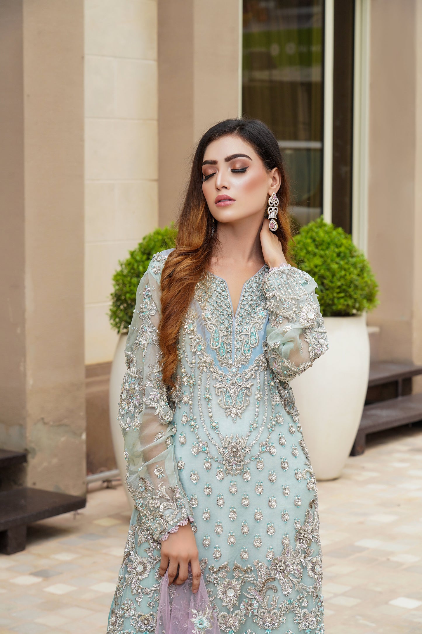 Stunning Pakistani formal dress in turquoise and violet colors, featuring a fitted bodice and flowing skirt, with a complementary pink dupatta. Perfect for formal occasions, this dress is eye-catching and unique with its beautiful color combination.