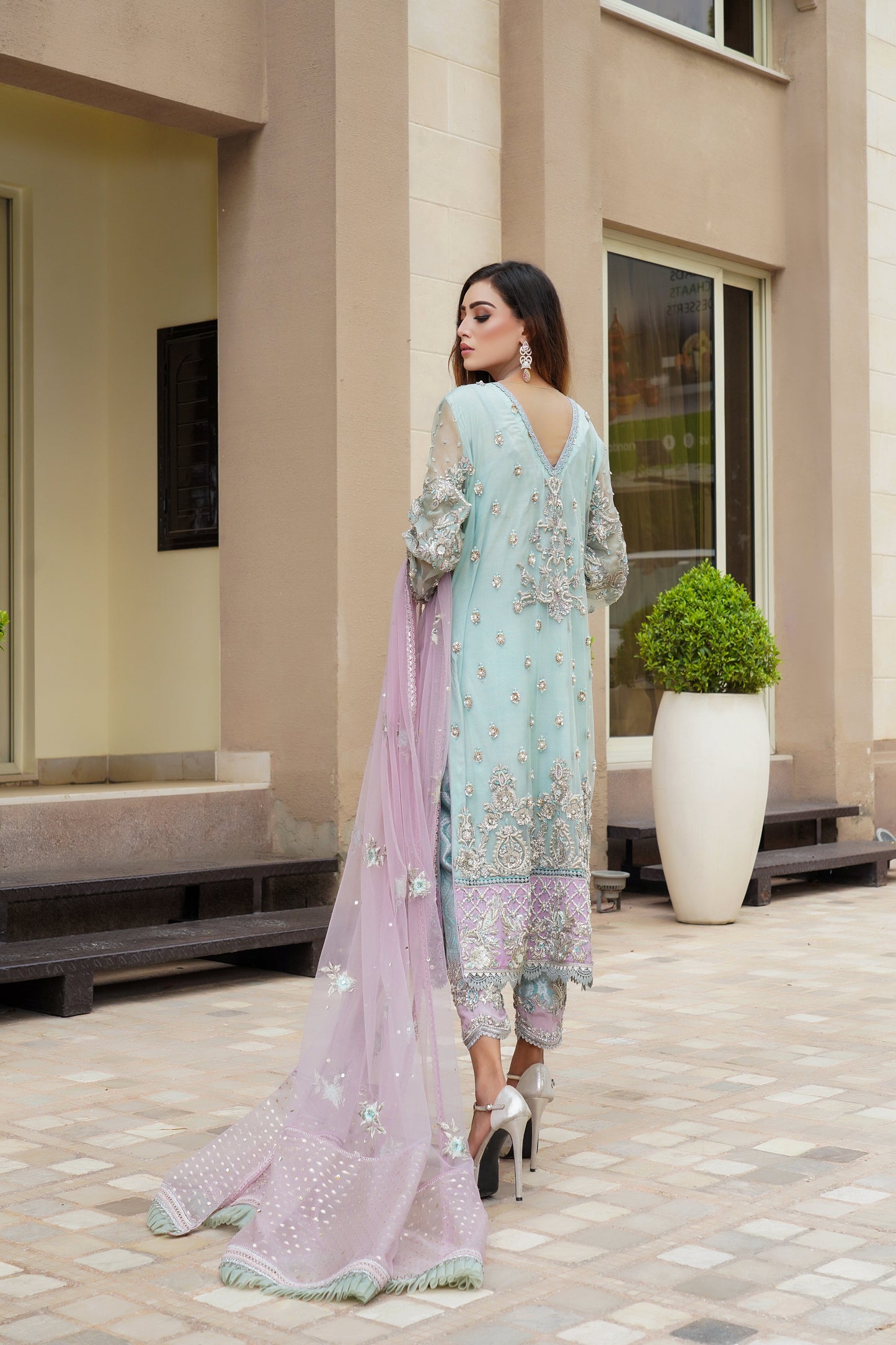 Ice blue Pakistani formal dress with intricate silver work and pink dupatta. Fitted bodice, flowing skirt, and delicate silver work throughout. Dazzling and elegant, perfect for formal events.