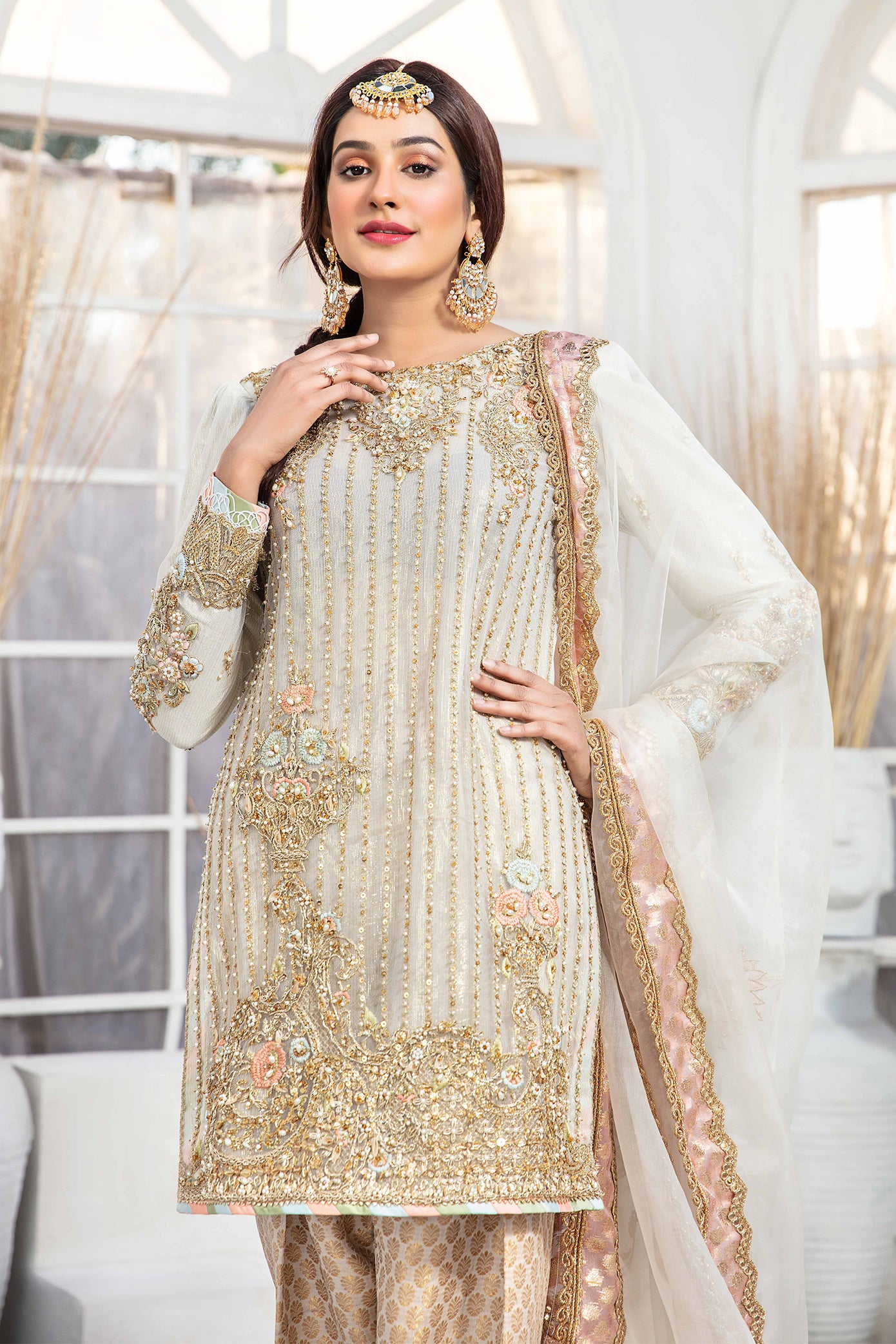 Elegant light gold Pakistani formal dress - Featuring intricate darker gold embroidery work that flows seamlessly down the length of the dress. Completed with a stunning white and rose gold dupatta that adds an extra layer of sophistication to the overall design. Perfect for any formal occasion, this dress is sure to impress with its attention to detail and elegant design