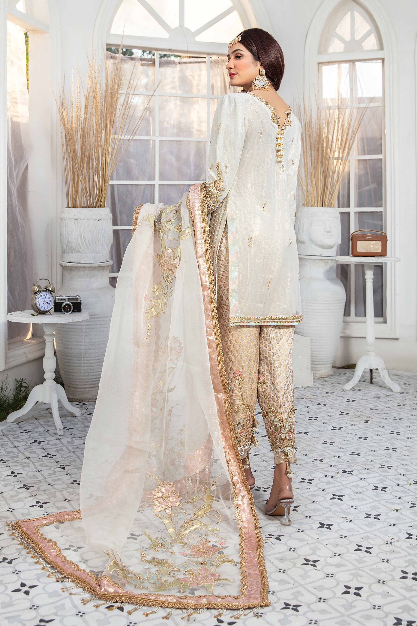 Elegant light gold Pakistani formal dress - Featuring intricate darker gold embroidery work that flows seamlessly down the length of the dress. Completed with a stunning white and rose gold dupatta that adds an extra layer of sophistication to the overall design. Perfect for any formal occasion, this dress is sure to impress with its attention to detail and elegant design