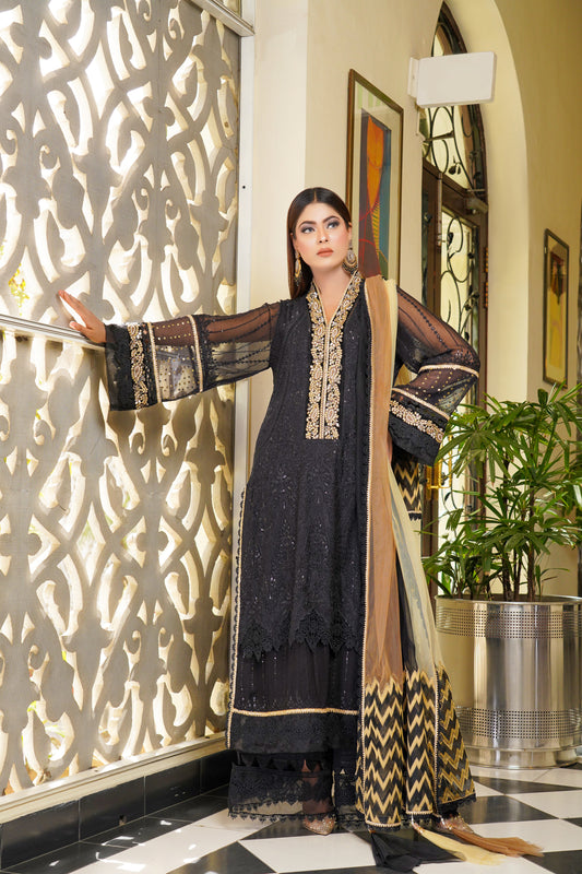 Luxurious black and gold Pakistani dress with intricate gold work around neckline and sleeves. Flattering fitted bodice and flowing skirt. Elegant v-neckline and long sleeves with stunning gold embroidery. Perfect for special occasions exuding confidence, power, and sophistication.