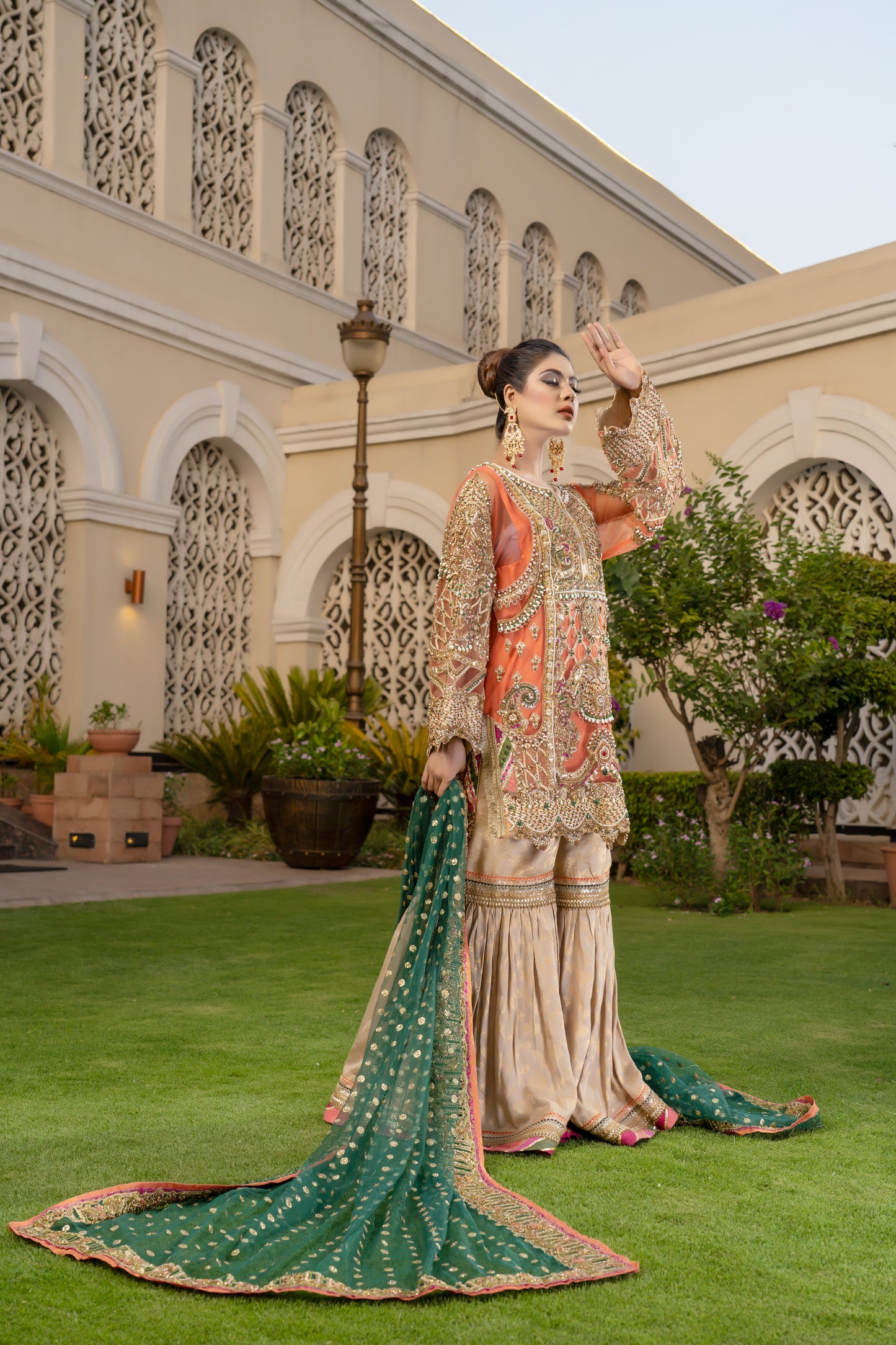 Gold threadwork, sequins, and beadwork in floral and paisley patterns dupatta draped over the head and shoulders Traditional Pakistani bridal attire Rich and vibrant color scheme Opulent and elegant bridal outfit.