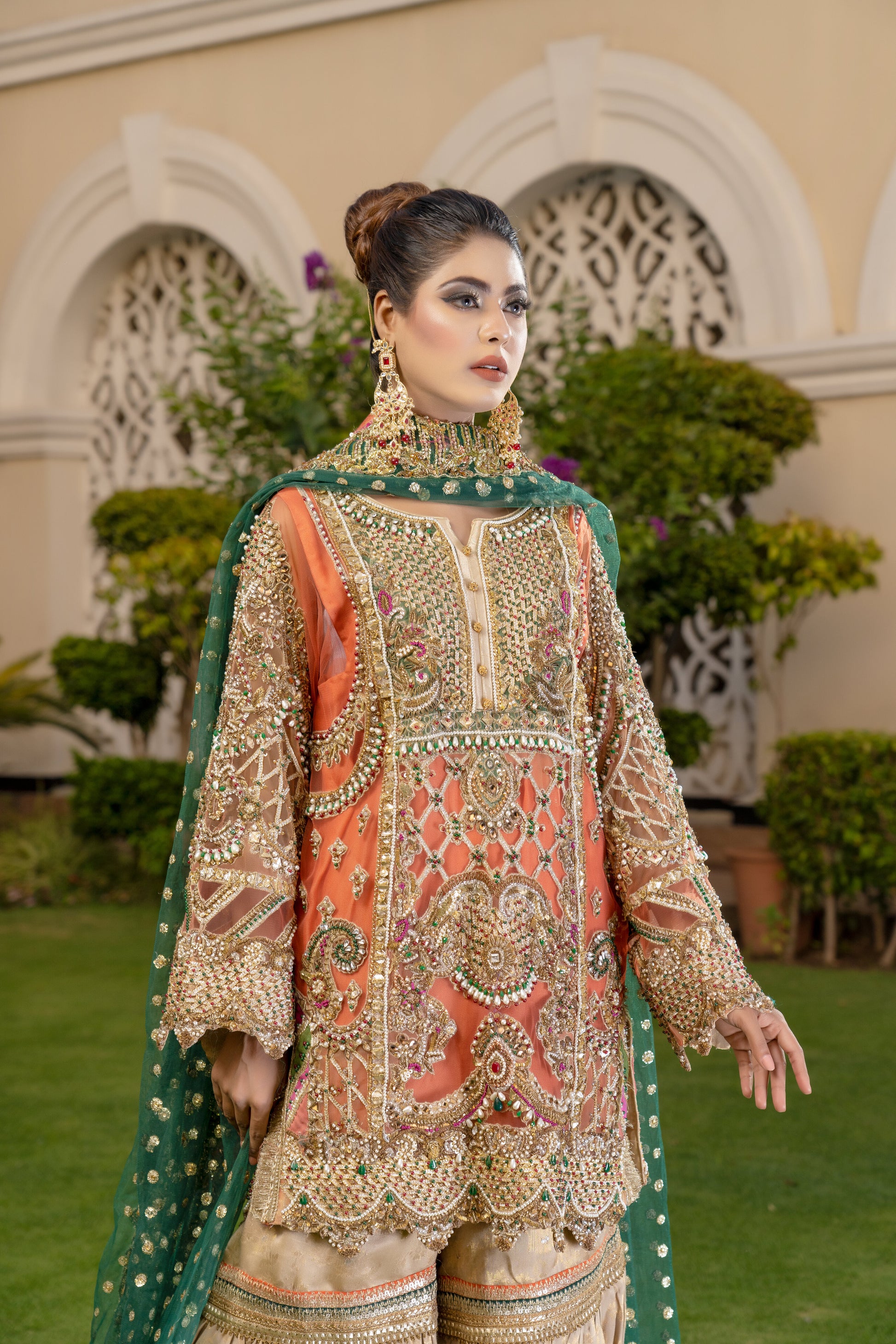 Gold threadwork, sequins, and beadwork in floral and paisley patterns dupatta draped over the head and shoulders Traditional Pakistani bridal attire Rich and vibrant color scheme Opulent and elegant bridal outfit.