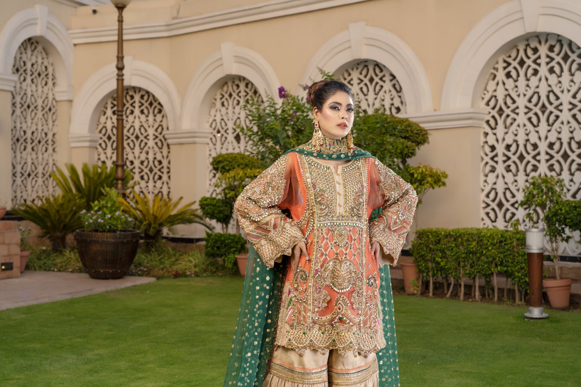 Gold threadwork, sequins, and beadwork in floral and paisley patterns dupatta draped over the head and shoulders Traditional Pakistani bridal attire Rich and vibrant color scheme Opulent and elegant bridal outfit.