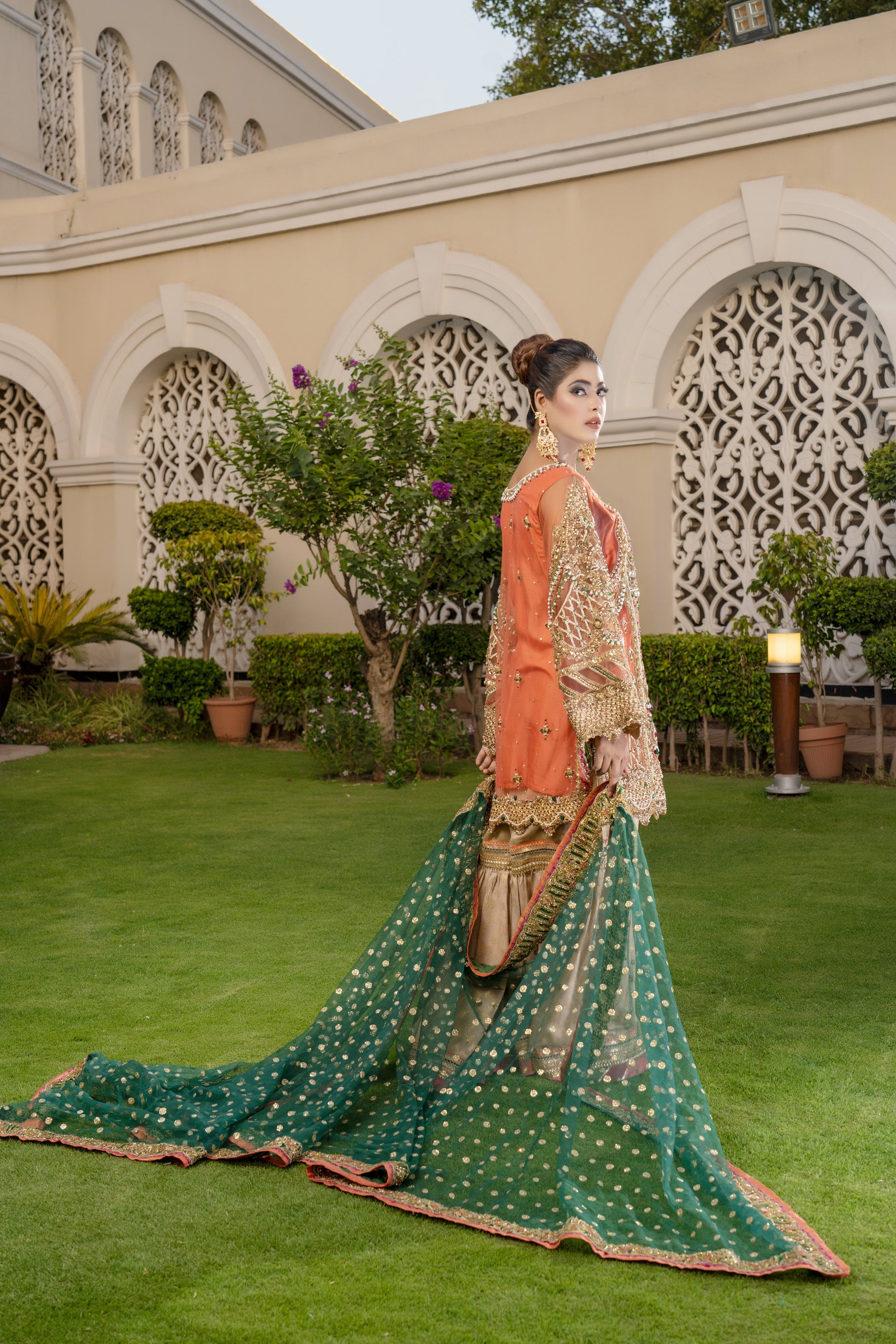 Gold threadwork, sequins, and beadwork in floral and paisley patterns dupatta draped over the head and shoulders Traditional Pakistani bridal attire Rich and vibrant color scheme Opulent and elegant bridal outfit.