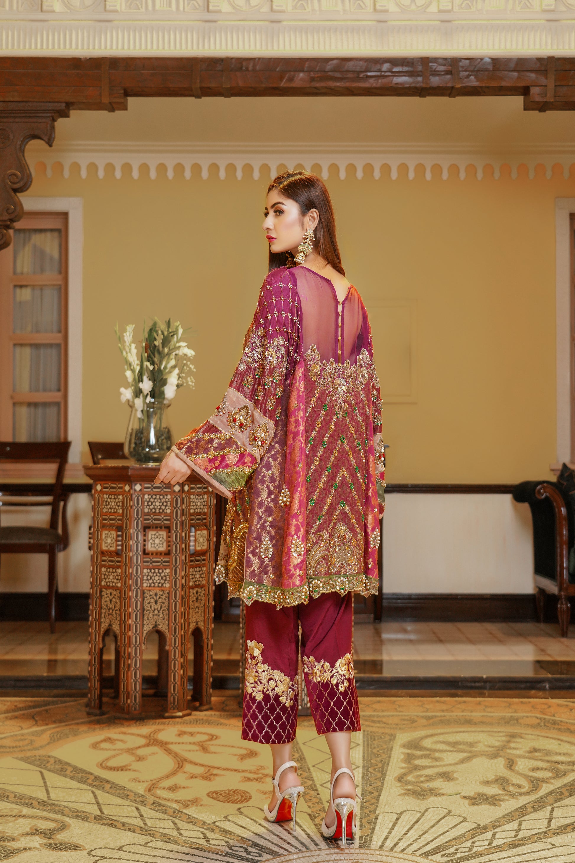 Stunning maroon and gold Pakistani formal dress, This dress features intricate gold embroidery on rich red fabric, with orange and green detailing on the sleeves that beautifully complements the overall design. Perfect for any formal occasion, this dress is a true work of art that exudes confidence and elegance